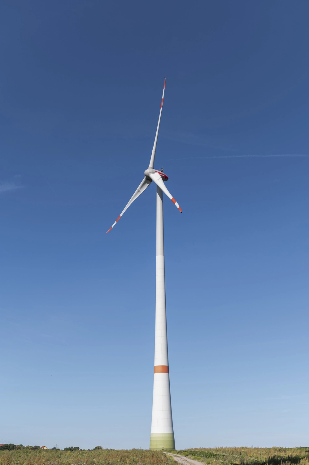 Lohrengel Consulting – Erneuerbare Energien – ein Windpark, der aus mehreren großen Windkraftanlagen auf einem Feld unter blauem Himmel besteht